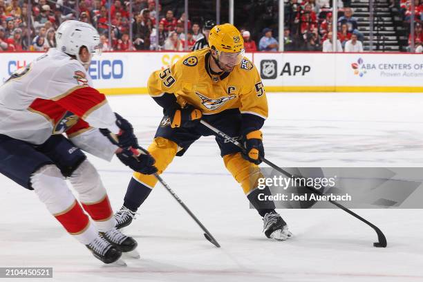 Roman Josi of the Nashville Predators plays the puck against Niko Mikkola of the Florida Panthers at the Amerant Bank Arena on March 21, 2024 in...