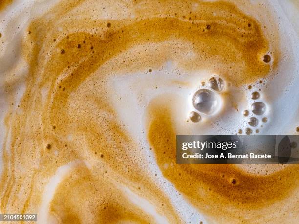full frame of cup with milk and coffee in motion are mixed. - capuccino fotografías e imágenes de stock