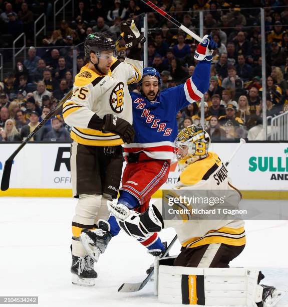 Brandon Carlo of the Boston Bruins checks Vincent Trocheck of the New York Rangers during the second period at the TD Garden on March 21, 2024 in...