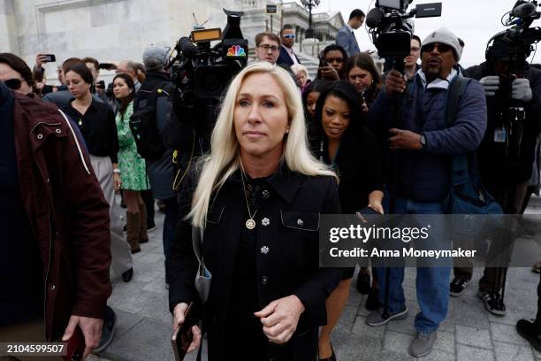 Rep. Marjorie Taylor Greene is followed by reporters after speaking outside of the U.S. Capitol Building following a vote on a funding bill that...