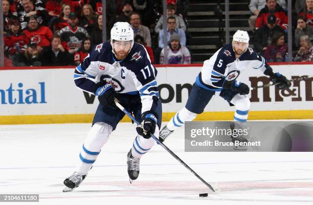 Adam Lowry of the Winnipeg Jets skates against the New Jersey Devils at Prudential Center on March 21, 2024 in Newark, New Jersey.