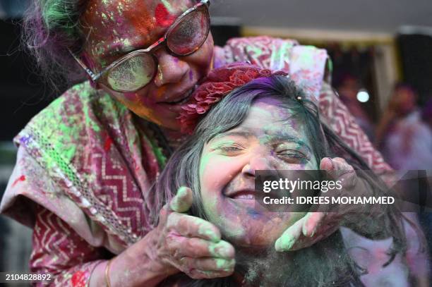 Woman along with a girl celebrates Holi, the Hindu spring festival of colours, in Bengaluru on March 25, 2024.
