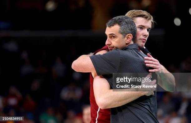 Sam Thomson of the Colgate Raiders and head coach Matt Langel of the Colgate Raiders hug after losing in the first round of the NCAA Men's Basketball...