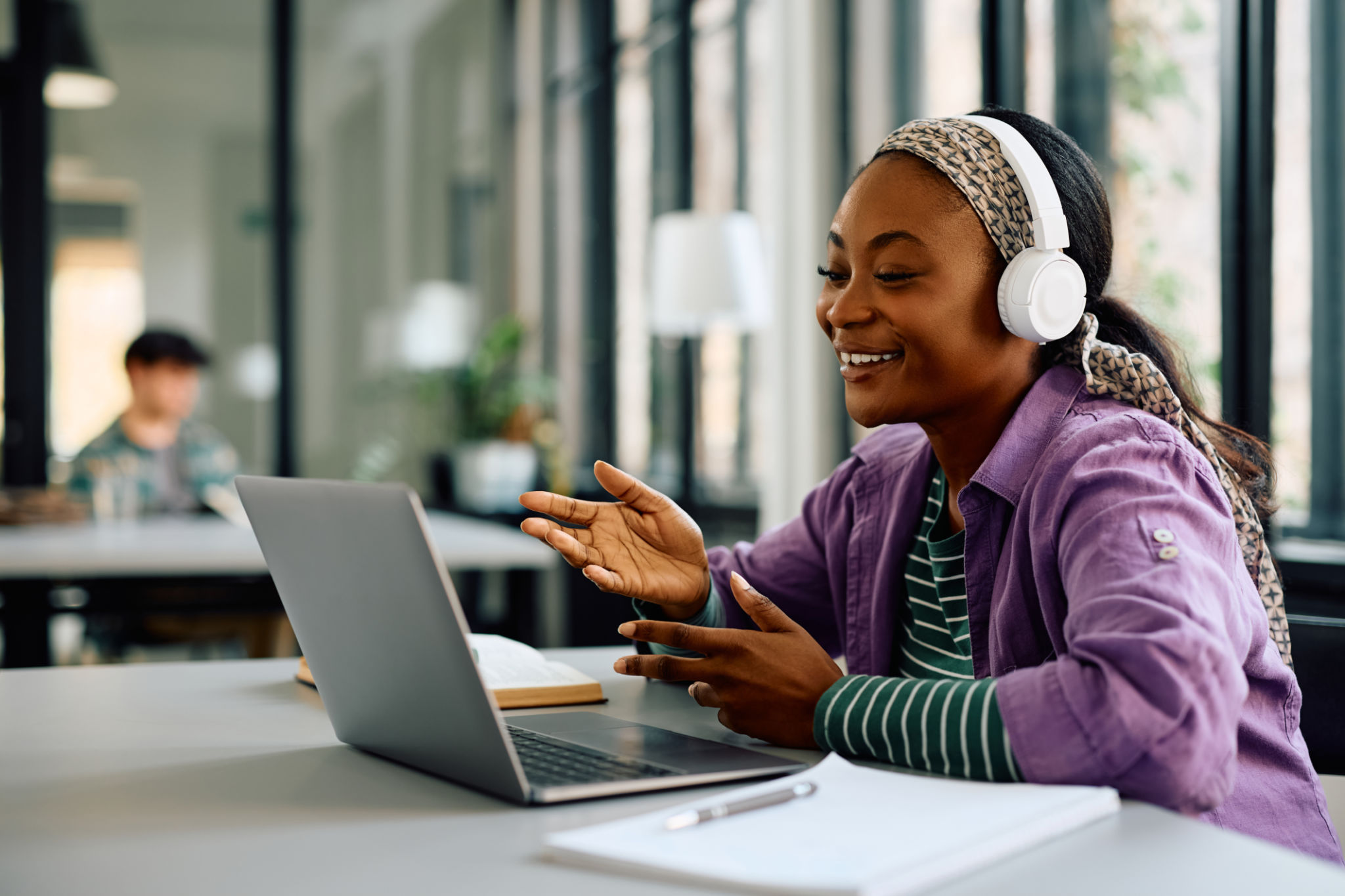 Happy black female student making video call via laptop at the university. Happy black female student making video call via laptop at the university.