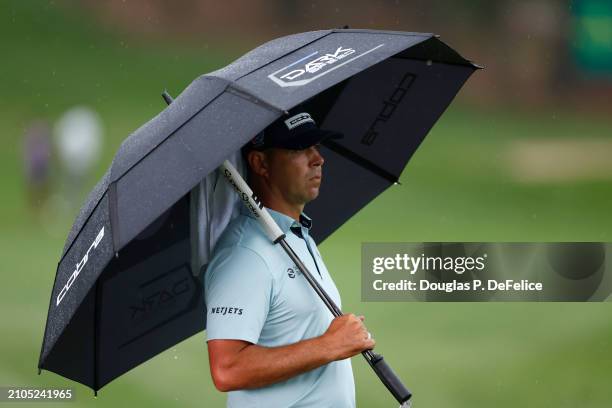 Gary Woodland of the United States looks on under an umbrella on the 18th green during the second round of the Valspar Championship at Copperhead...