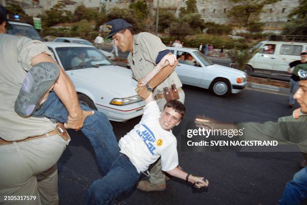 Israeli police evacuate a young settler blocking the main entry to Jerusalem on the Tel Aviv highway on June 30, 1994 in protest against the arrival...