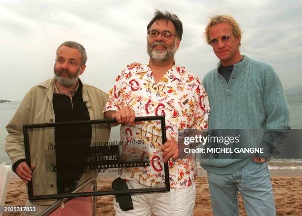 Director Francis Ford Coppola poses with British director Mike Leigh and French actor Christophe Lambert 12 May after being awarded a " Pubic Palm "...