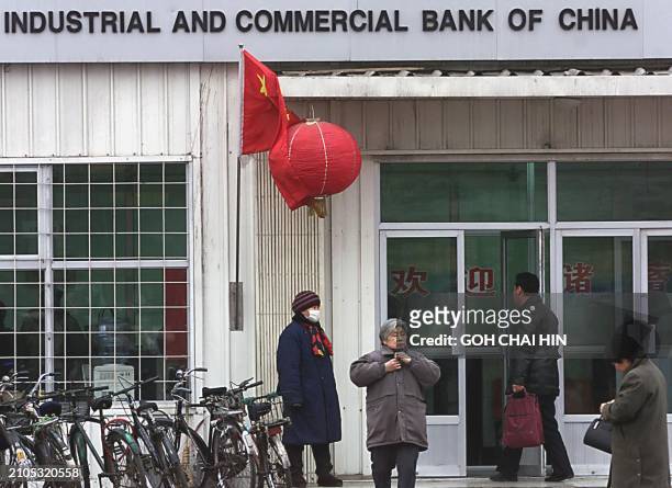 Bank customers make their way in and out of a bank in Beijing, 03 January 2000, as Chinese banks opened for business as usual in the new year. A...