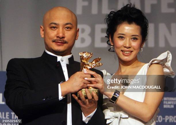 Chinese director Wang Quan'an and his lead actress Nan Yu hold up their trophy during the closing press conference of the 57th Berlinale...