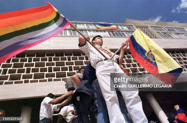 Quito demonstrator waves the Ecuadoran flag and the Huipala indigenous flag 21 January outside the National Congress after a military junta led by...