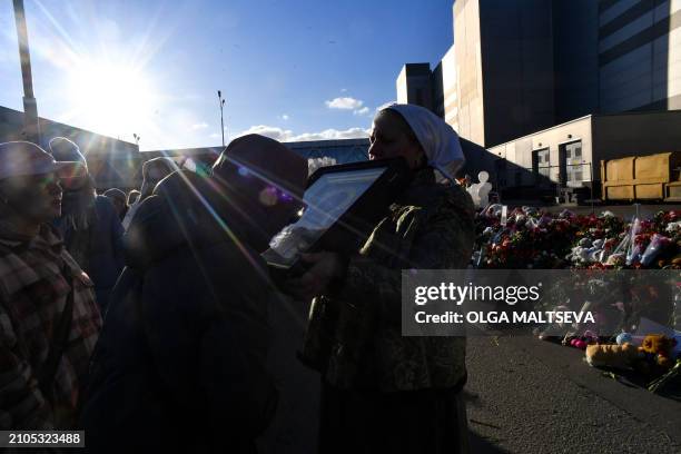 Woman kisses an icon during a religious service at a makeshift memorial in front of the burnt-out Crocus City Hall concert venue in Krasnogorsk,...