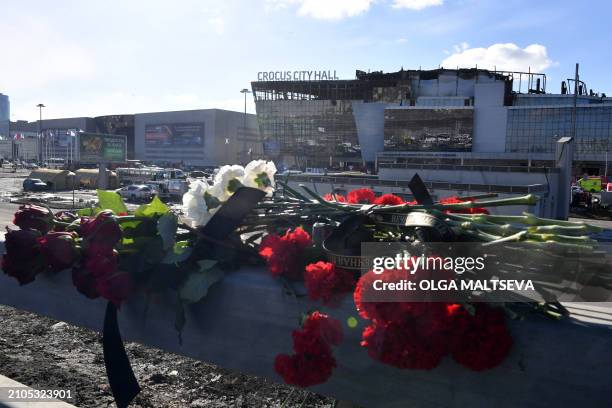 Flowers are seen left by the burnt-out Crocus City Hall concert venue in Krasnogorsk, outside Moscow, on March 25, 2024. At least 137 people were...