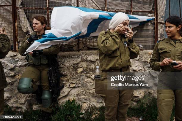 Israeli soldier puts on make up and a wig to join religious Israelis who gathered in costumes to march in a parade to celebrate the Jewish holiday of...