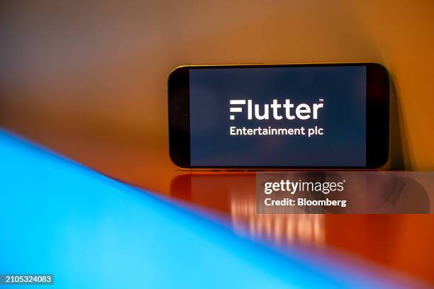 The logo of Flutter Entertainment Plc on a smartphone arranged in London, UK, on Monday, March 25, 2024. Flutter are to due to report their 2023 full...