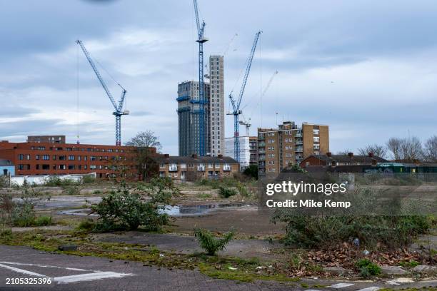 New residential apartment buildings under construction seen beyond waste ground as part of a development / redevelopment close to the city centre as...