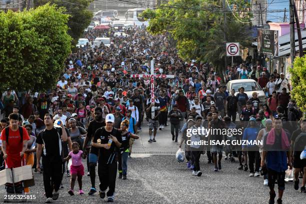 Group of migrants of different nationalities carry a cross leading a caravan that aims to reach the border between Mexico and the United States,...