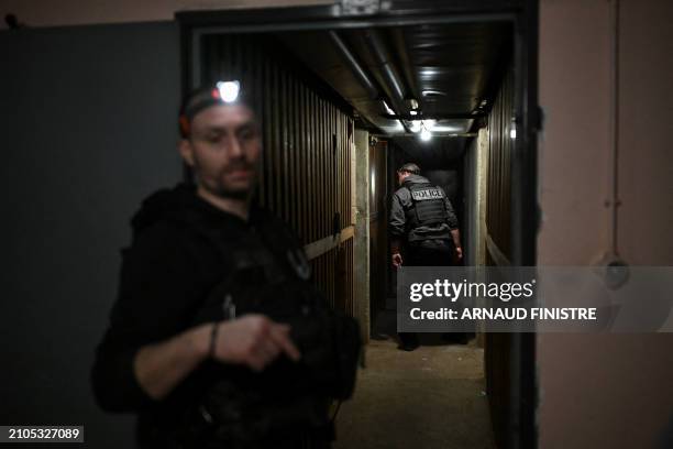 Police officers patrol in the basement of a building in Chenove, central eastern France, on March 25 as part of the "XXL cleanup operation" launched...