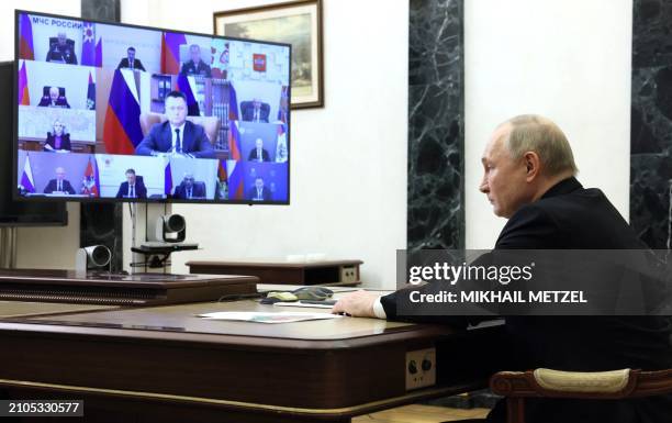 In this pool photograph distributed by the Russian state agency Sputnik, Russia's President Vladimir Putin holds a meeting on measures taken after a...