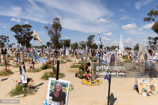 An Israeli soldier pays a tribute for a victim at the 'Nova' party memorial site for the victim of Oct' 7 Hamas attack on March 25, 2024 in Re'im,...