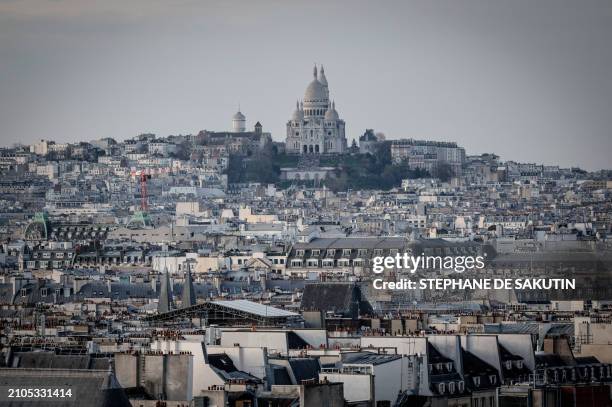 This photograph taken in Paris on March 21, 2024 shows a view of the Sacre-Coeur basilica and roofs of Paris.