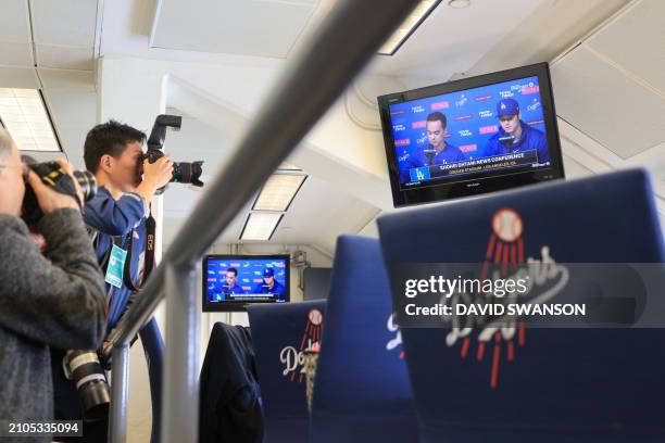 The Los Angeles Dodgers' Shohei Ohtani delivers a statement during a closed press conference as seen on a TV in the press box at Dodger Stadium in...