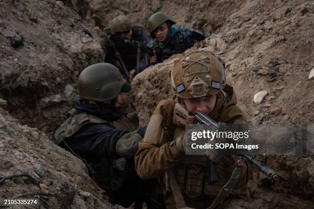 Trainees react during a training simulating an evacuation mission in the trench organised by the third separate assault brigade in Kyiv region....