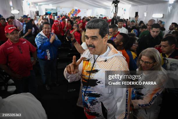 Venezuela's President Nicolas Maduro leaves the headquarters of the National Electoral Council with First Lady Cilia Flores after formalizing his...