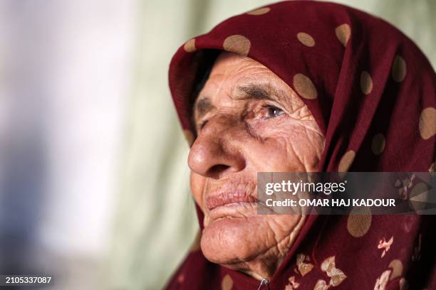 Amina al-Hamam whose son Ghazwan Hassun was detained by Hayat Tahrir al-Sham in 2019, looks on as she sits inside her tent at a camp for those...