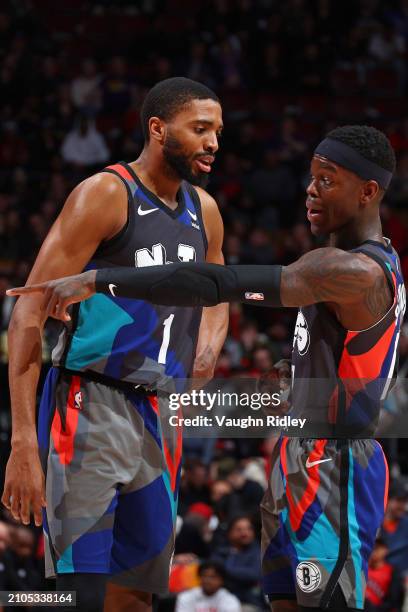 Dennis Schroder of the Brooklyn Nets talks to Mikal Bridges during the game against the Toronto Raptors on March 25, 2024 at the Scotiabank Arena in...