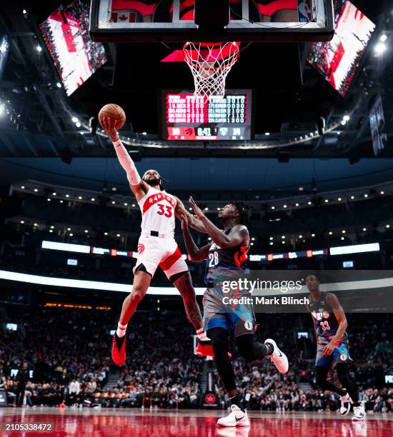 Gary Trent Jr. #33 of the Toronto Raptors goes to the basket against Dorian Finney-Smith of the Brooklyn Nets during the first half of their...