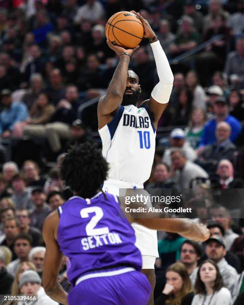 Tim Hardaway Jr. #10 of the Dallas Mavericks shoots over Collin Sexton of the Utah Jazz during the second half of a game at Delta Center on March 25,...