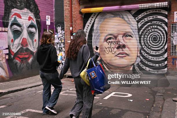 People walk past a mural of WikiLeaks founder Julian Assange in a Melbourne laneway on March 26, 2024. Assange will find out March 26 whether he can...