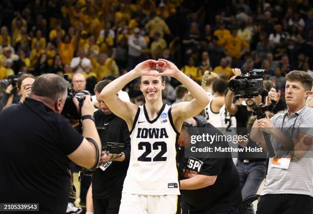 Guard Caitlin Clark of the Iowa Hawkeyes gestures to the crowd as she leaves the court after the game against the West Virginia Mountaineers during...