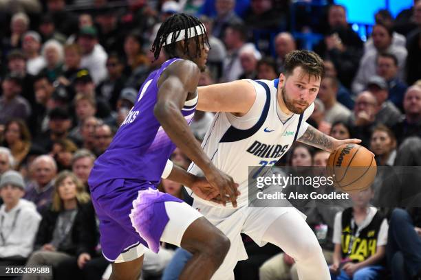 Luka Doncic of the Dallas Mavericks drives into Taylor Hendricks of the Utah Jazz during the second half of a game at Delta Center on March 25, 2024...