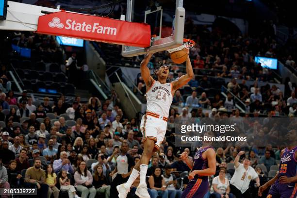 Devin Vassell of the San Antonio Spurs dunks past Grayson Allen of the Phoenix Suns in the second half at Frost Bank Center on March 25, 2024 in San...