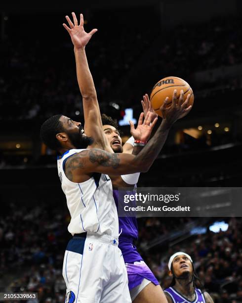 Kyrie Irving of the Dallas Mavericks shoots over Johnny Juzang of the Utah Jazz during the second half of a game at Delta Center on March 25, 2024 in...