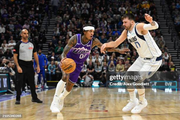 Jordan Clarkson of the Utah Jazz drives into Luka Doncic of the Dallas Mavericks during the first half of a game at Delta Center on March 25, 2024 in...