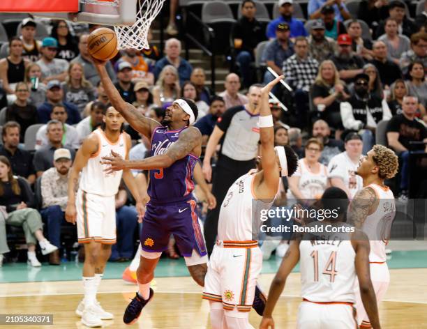 Bradley Beal of the Phoenix Suns drives to the basket against Keldon Johnson of the San Antonio Spurs in the first half at Frost Bank Center on March...