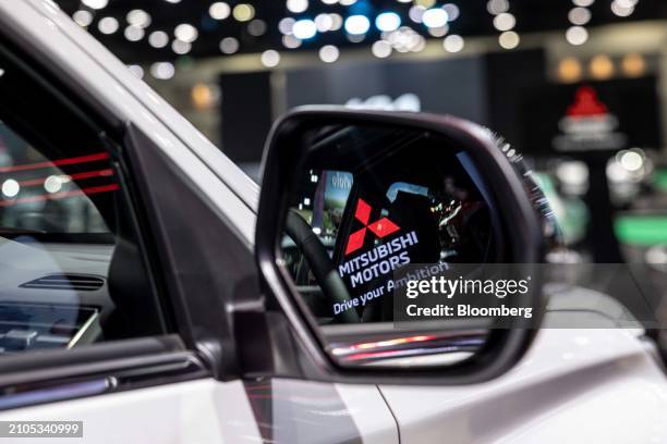 The Mitsubishi Motors Corp. Signage reflected on the side view mirror of a company's Pajero Sport vehicle on display at the Bangkok International...