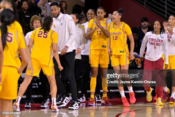 McKenzie Forbes, Rayah Marshall and JuJu Watkins celebrate with assistant coach Wendale Farrow of the USC Trojans after defeating against the Kansas...