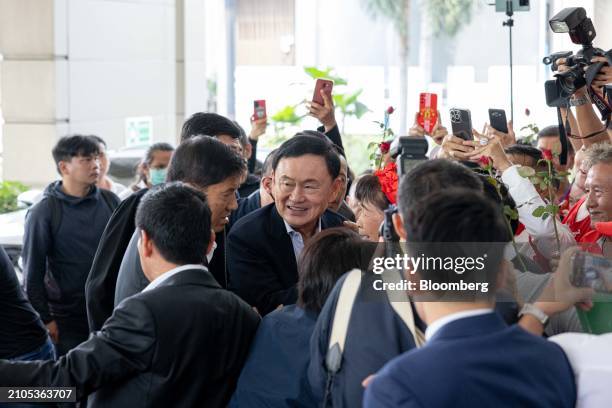 Thaksin Shinawatra, Thailand's former prime minister, center, arrives at the Pheu Thai party headquarters in Bangkok, Thailand, on Tuesday, March 26,...