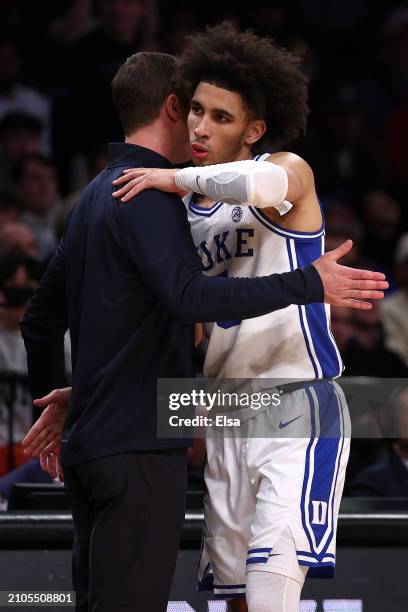 Head coach Jon Scheyer of the Duke Blue Devils hugs Tyrese Proctor during the second half against the Vermont Catamounts in the first round of the...