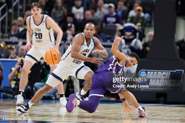 Darius Brown II of the Utah State Aggies fights for a loose ball with Jameer Nelson Jr. #4 of the TCU Horned Frogs during the first half in the first...
