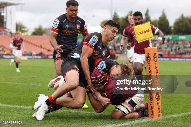 Damian McKenzie and Shaun Stevenson of the Chiefs tackle Billy Harmon of the Highlanders into touch during the round five Super Rugby Pacific match...