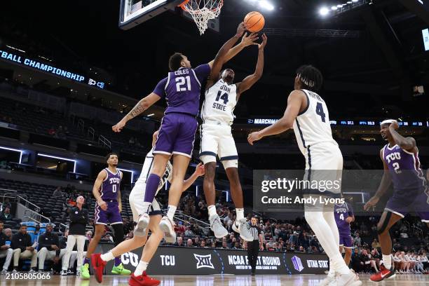 Josh Uduje of the Utah State Aggies fights for a rebound with JaKobe Coles of the TCU Horned Frogs during the second half in the first round of the...