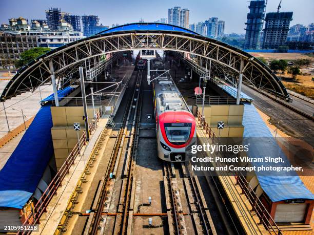 drone shot of rapid transit system / elevated metro train 's arrival and departure at the train station in kharghar, navi mumbai, india. - underground rail stock pictures, royalty-free photos & images