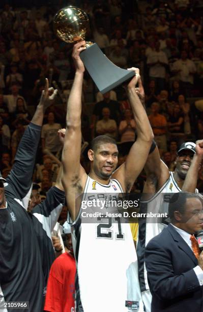 Tim Duncan of the San Antonio Spurs raises his NBA MVP trophy after Game six of the 2003 NBA Finals against the New Jersey Nets at SBC Center on June...