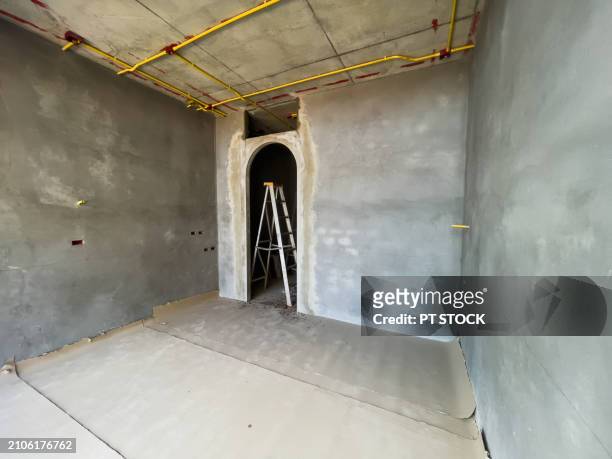 a large empty room with yellow pipes on the ceiling. the room is unfinished and has a very industrial feel - unfinished basement stock pictures, royalty-free photos & images