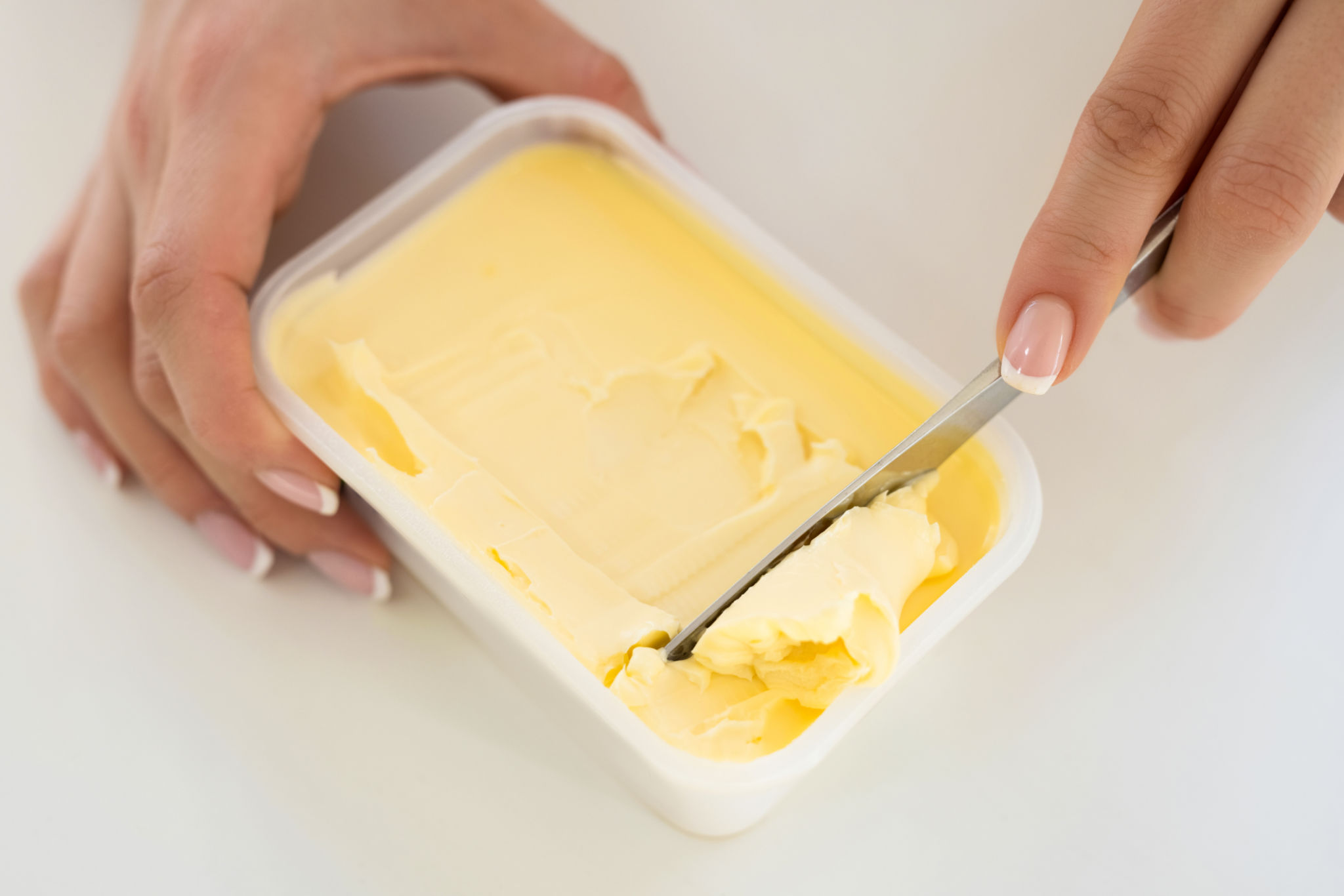 Butter in plastic container with knife Butter in plastic container with knife