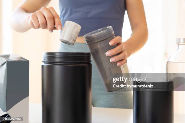 woman preparing protein shake at home - protein powder stock pictures, royalty-free photos & images